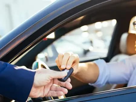 Une personne remettant les clés de son véhicule après avoir vendu sa voiture épave